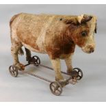 A blonde plush covered pull-along toy cow, late 19th century,