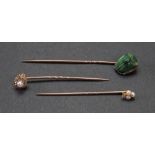 A collection of three rose precious metal stick pins,