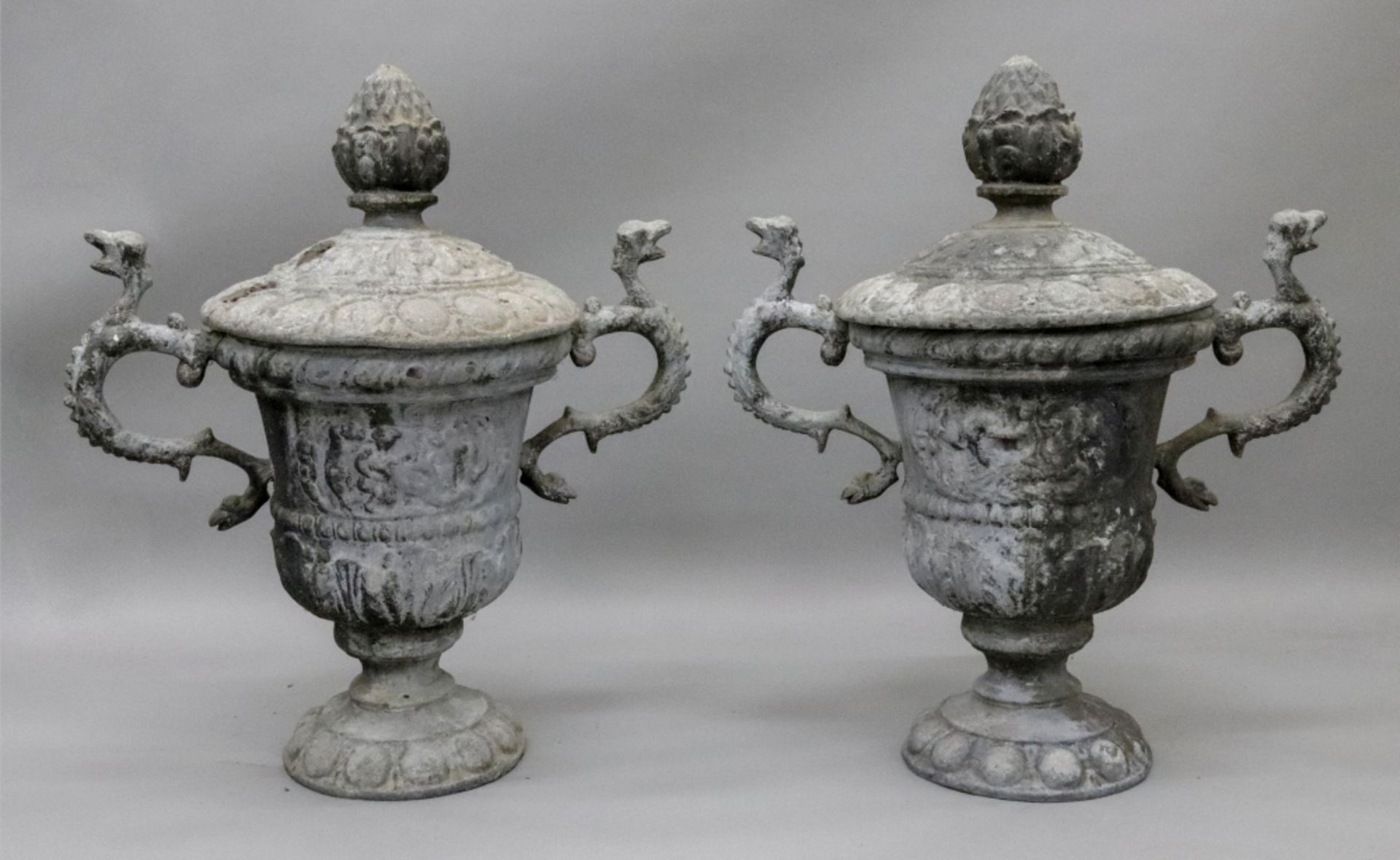 A pair of weathered lead terrace urns and covers, after the antique,