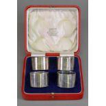 A cased set of four circular silver napkin rings, E S Barnsley & Co, Birmingham 1921, numbered 1-4,