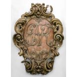 A large and impressive early 18th century pine wall shield, of cartouche shape, polychrome painted,