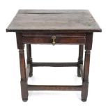 A late 17th century oak side table, the cleated planked rectangular top above a frieze drawer,