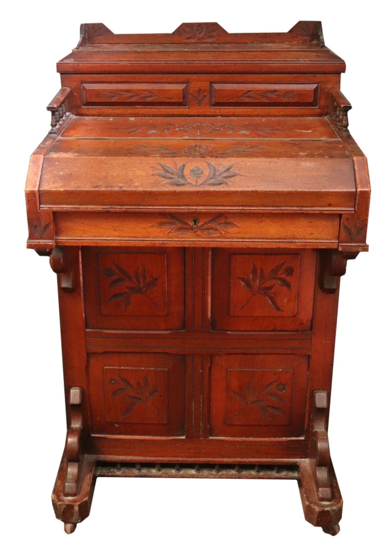 A late Victorian foliate carved walnut piano front davenport, of panelled construction,