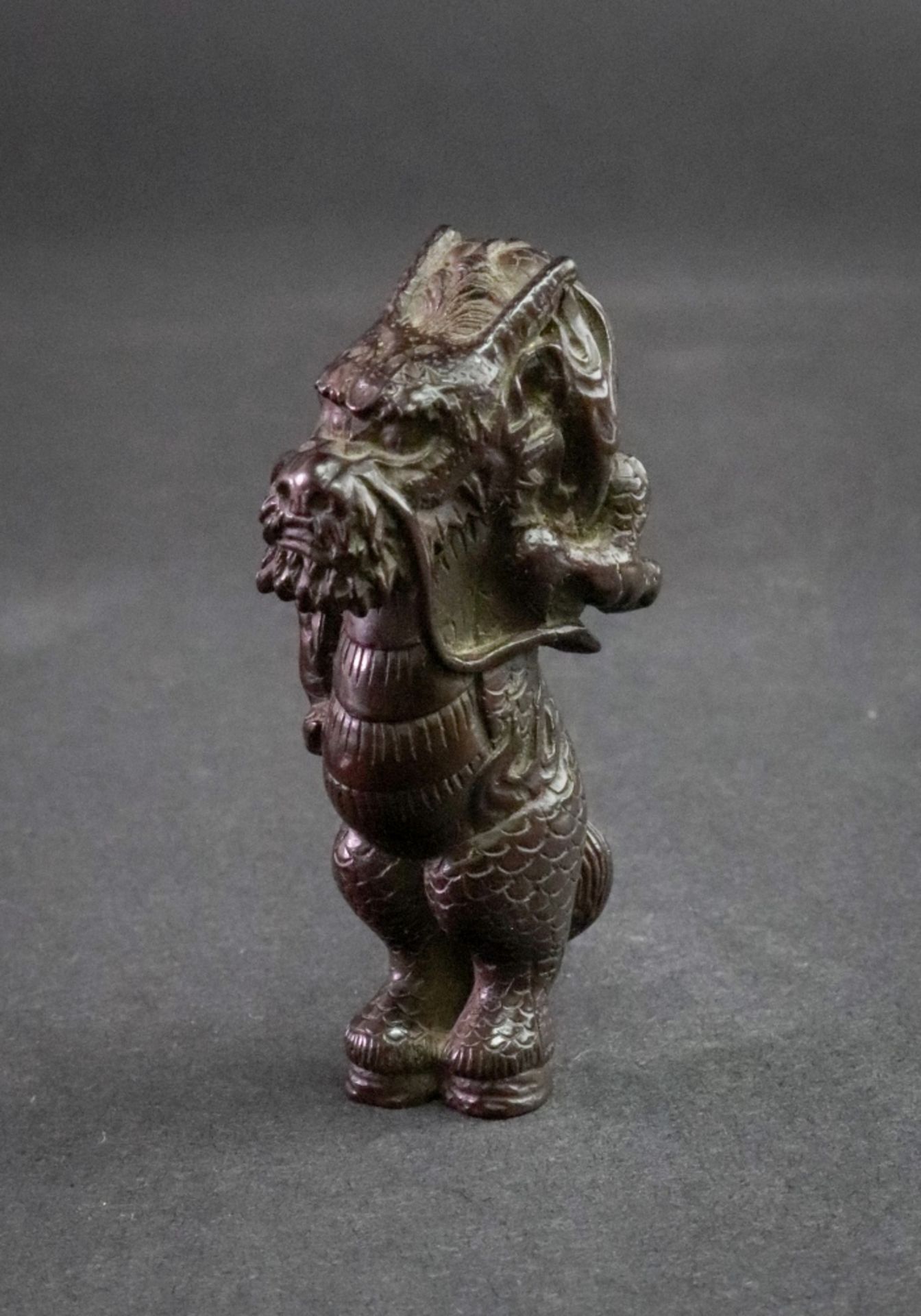 A carved wood Japanese netsuke of a dragon, signed to leg, 6.5cm high.