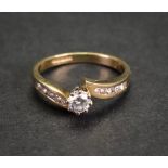 An 18ct gold and diamond-set ring, the central claw-set brilliant-cut diamond approximately 0.
