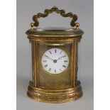 An oval brass cased carriage clock, circa 1880, engraved with flowers and leafy scrollwork,