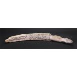 Scrimshaw; the curved bone of shaped outline, carved on both sides with a snake,