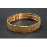 A 9ct yellow gold wide bracelet of textured stylized brick-link design,