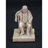 Of Napoleonic interest; a carved ivory figure of Napoleon seated sideways on a chair,