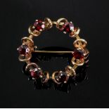 A 9ct gold and six-stone garnet-set brooch, of circular openwork design, detailed '9ct', 3g gross.