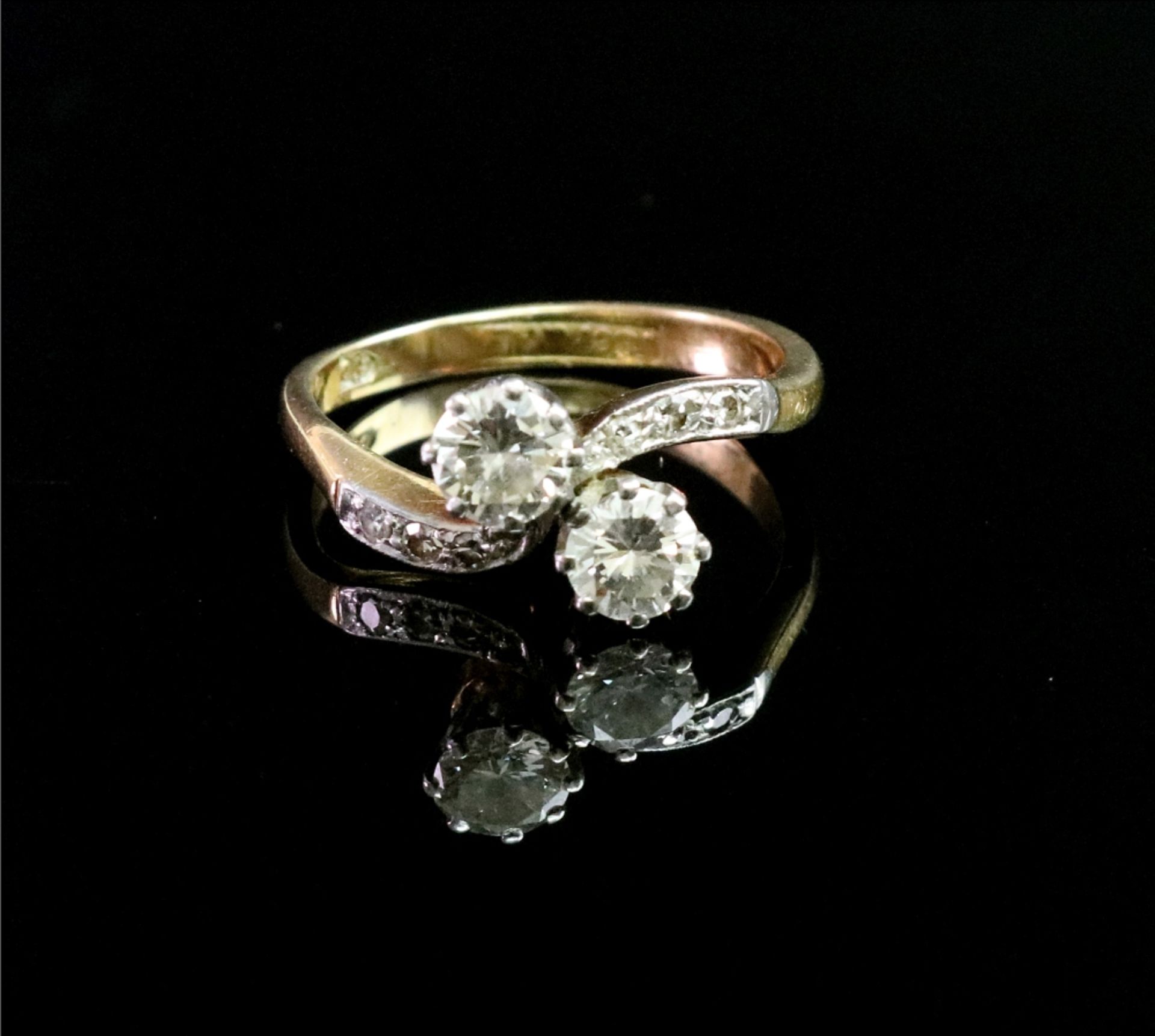 An 18ct gold and platinum diamond cross-over ring,