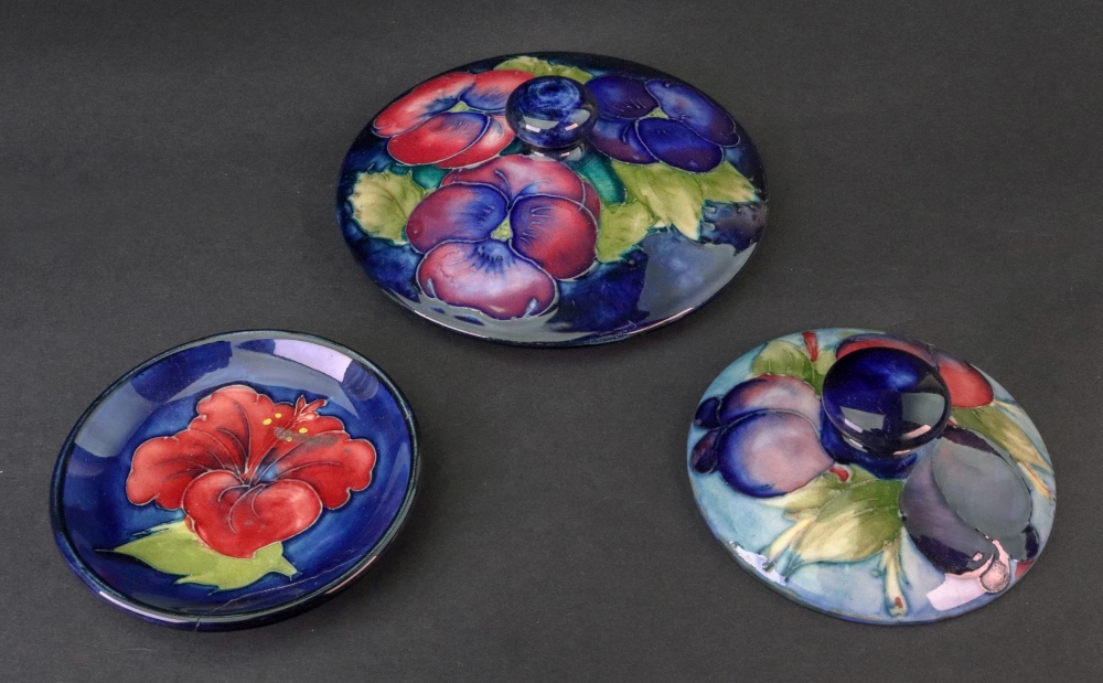 Two Moorcroft jar covers, Pansy and Wisteria Plum patterns,