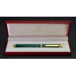 Must de Cartier Paris; a gold plated and green lacquer faux marble ball point pen, in fitted case.