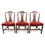 A set of three George III Hepplewhite style mahogany dining chairs,