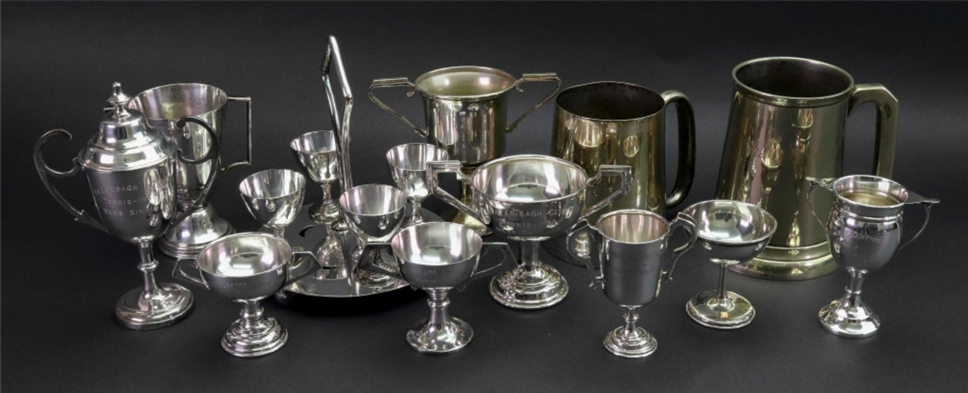 A collection of electroplate tennis and golf trophies,