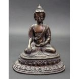 A gilt metal figure of Buddha, seated cross legged, on a lotus flower, 20cm high. Illustrated.