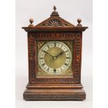 An Edwardian carved oak mantel timepiece, in an architectural style case,