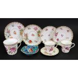 A Dresden large tea cup and pair of saucers, painted with bouquets and scattered flowers,