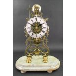 A Victorian brass skeleton clock, of open scrollwork form, the silvered dial with Roman numerals,