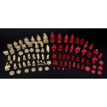 A collected Chinese carved ivory chess set, 19th century, one half stained red, the kings 9cm high.