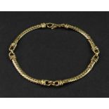 An 18ct gold bracelet of alternating herringbone and snaffle-bit-link design,