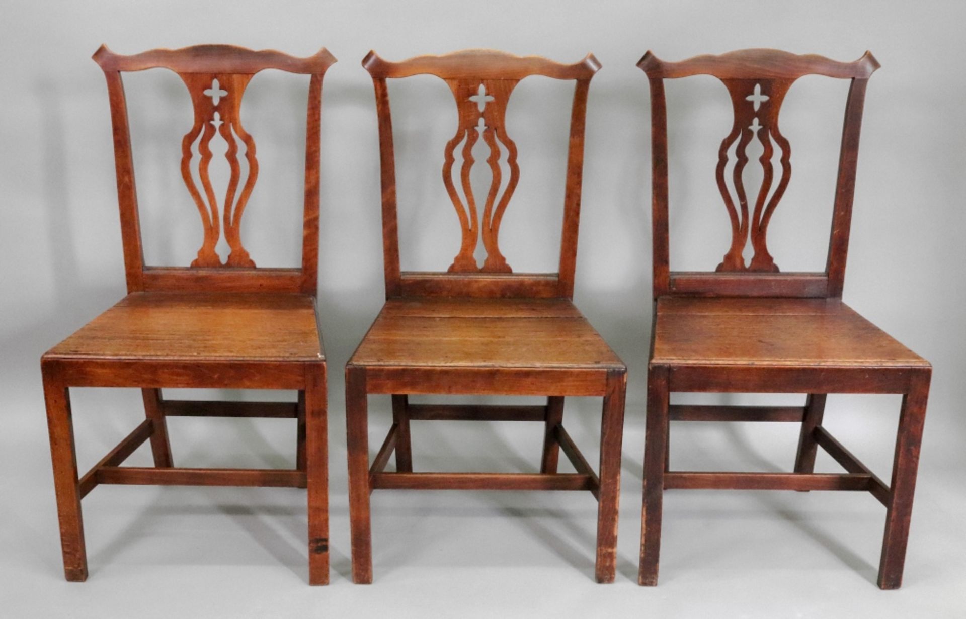 A set of six George III country Chippendale style oak and elm dining chairs,