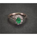 An emerald and diamond cluster ring, the