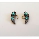 A pair of blue zircon two stone earclips, each in a curved design,