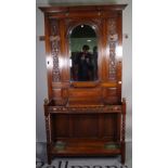 A Victorian oak hall stand, with central mirror over a pair of stick stands and glove box,