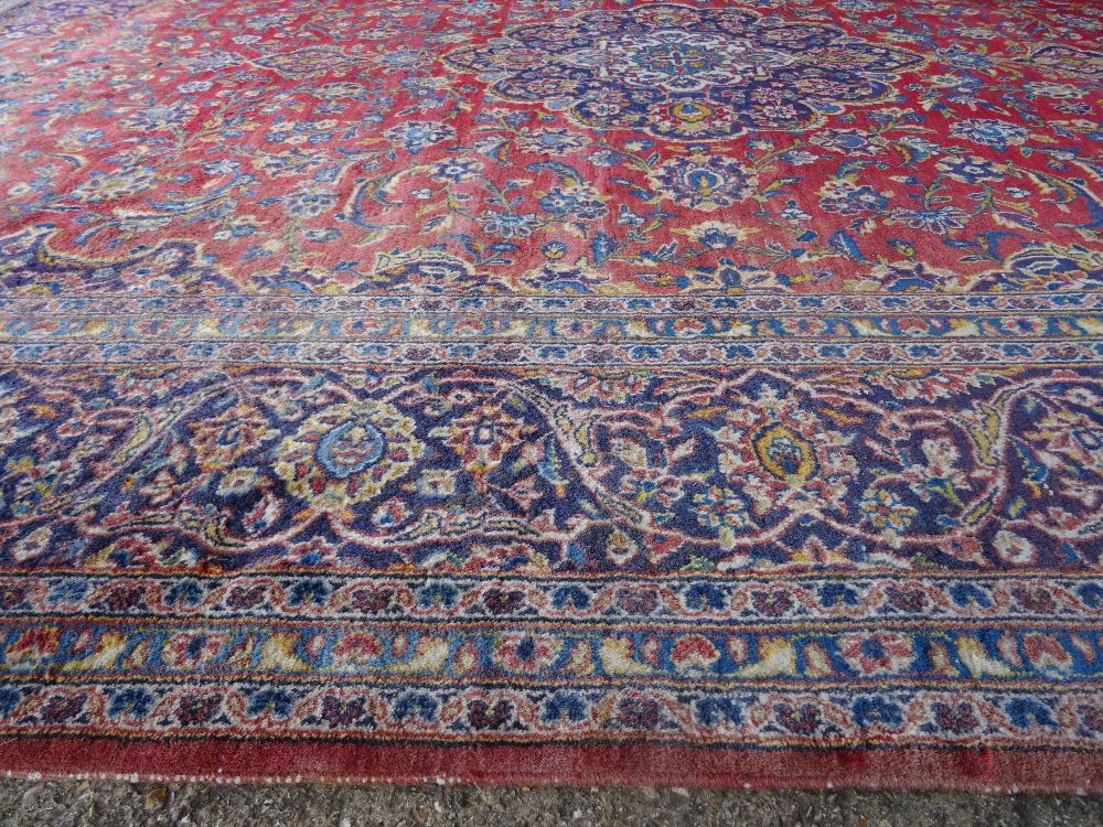 A Kashan carpet, Persian, the madder field with a bold indigo medallion, matching spandrels, - Image 6 of 7