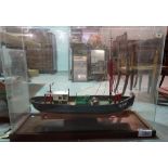 A large 20th century scratch built model of a fishing boat, in a glass case,