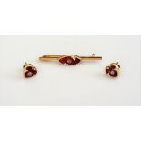 A gold, enamelled and diamond set bar brooch, the oval centre mounted with a cushion shaped diamond,