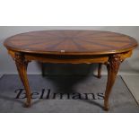 A 20th century walnut oval extending dining table, with inlaid sunburst decoration,