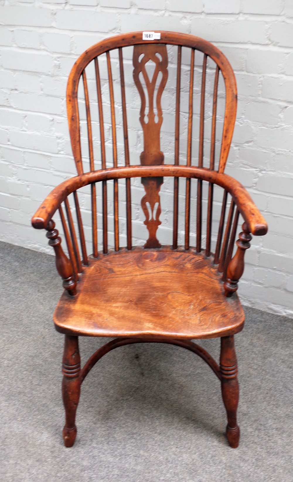 A 19th century yew and elm Windsor chair on turned supports united by crinoline stretcher,