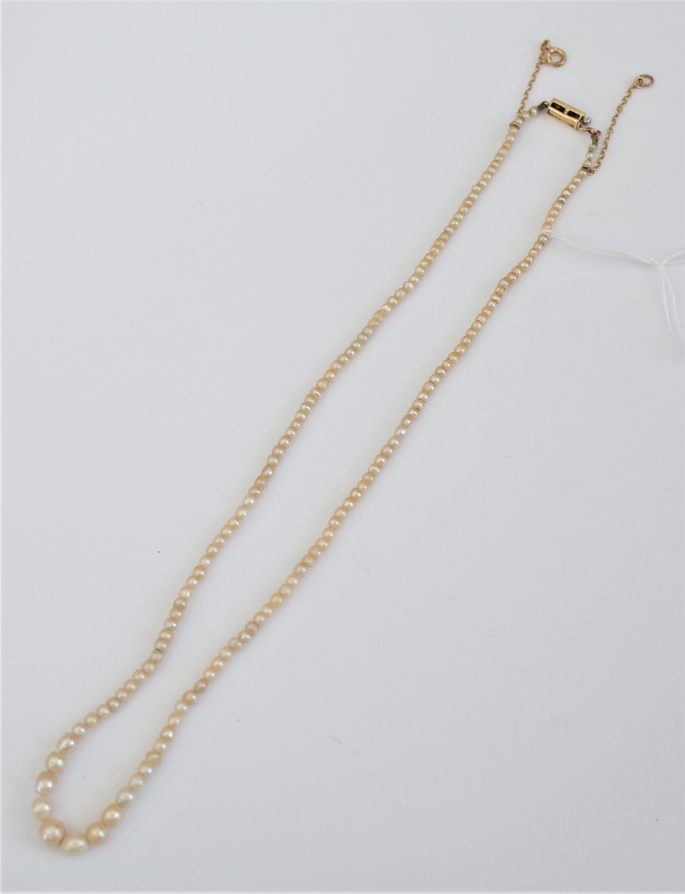 A single row necklace of graduated seed pearls,