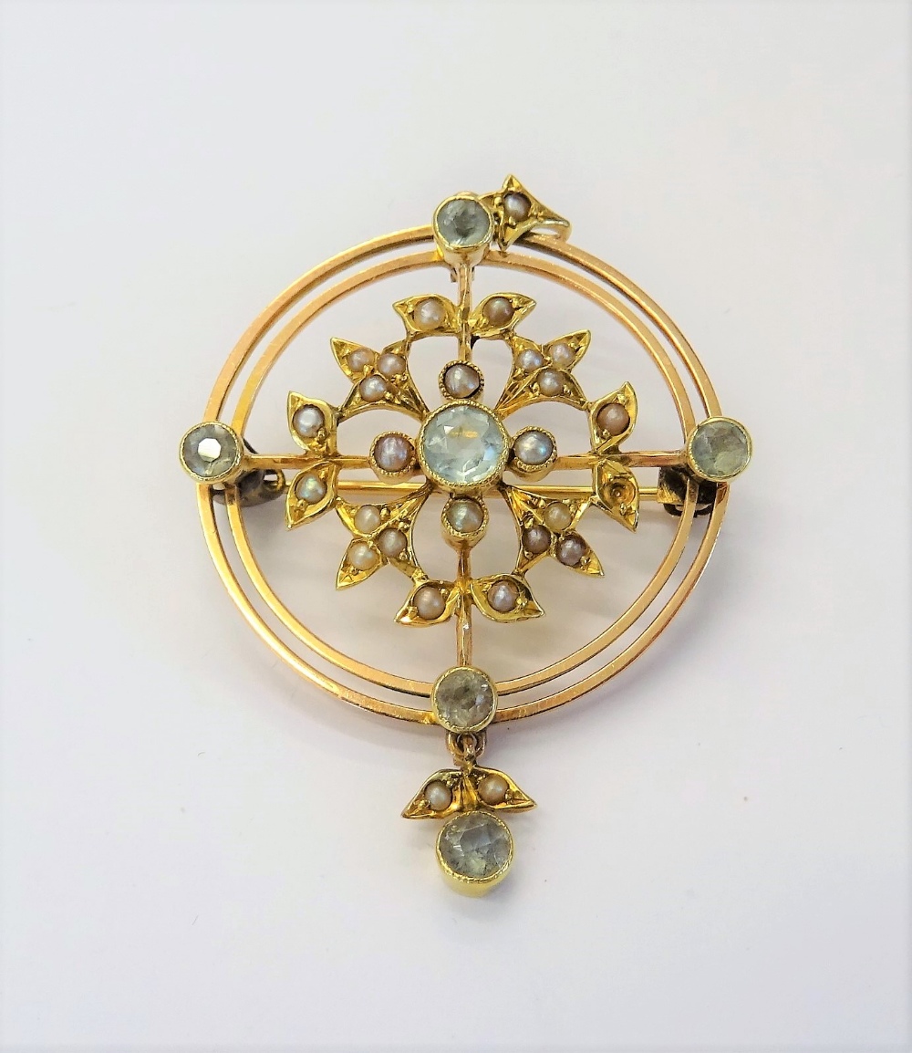 A gold, aquamarine and seed pearl set pendant brooch, in a circular openwork design,