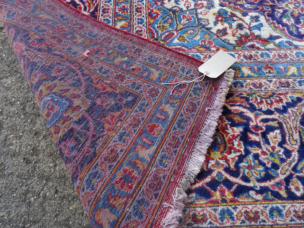 A Kashan carpet, Persian, the madder field with a bold indigo medallion, matching spandrels, - Image 4 of 7