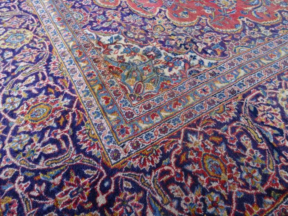 A Kashan carpet, Persian, the madder field with a bold indigo medallion, matching spandrels, - Image 5 of 7