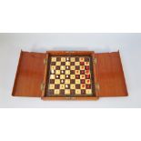 An early 20th century mahogany cased travelling chess set with stained bone pieces, king 1.