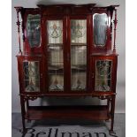 A late Victorian mahogany glazed display cabinet, with Art Nouveau stained glass motifs,