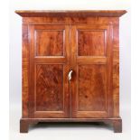 A William IV mahogany cabinet, fitted with shelves enclosed by a pair of panelled doors,