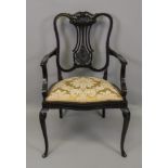 An Edwardian 'Chippendale Revival' dark stained foliate carved mahogany salon elbow chair.