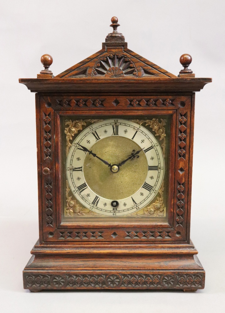 An Edwardian carved oak mantel timepiece