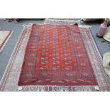 An Indian Bokhara rug, russet field, three columns, 177cm x 128cm.