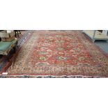 A Fereghan carpet, Persian, the madder field with a bold all over palmette and floral vine design,