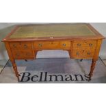 A Victorian mahogany writing desk with five drawers about the knee on tapering turned supports