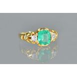 A gold, emerald and diamond set three stone ring, mounted with the step cut emerald at the centre,