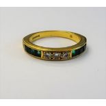An 18ct gold, emerald and diamond half hoop ring, set with three circular cut diamonds,