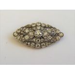 A diamond set brooch, circa 1920, of scalloped lozenge design,