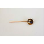A gold, diamond and sapphire set stick pin, the dished circular top with a trefoil shaped motif,